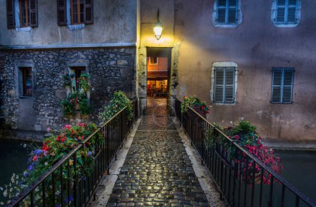 A photo of a historic cobblestone street leading to a building illuminated by a glowing light.