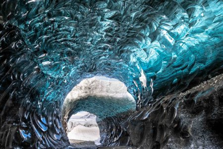 A large blue ice cave with water pouring out, creating a striking natural spectacle.