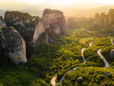 Meteora, Greece. Sandstone rock formations, the Rousanou and Nikolaos monasteries at sunset. Travel destination background. Panoramic view. 