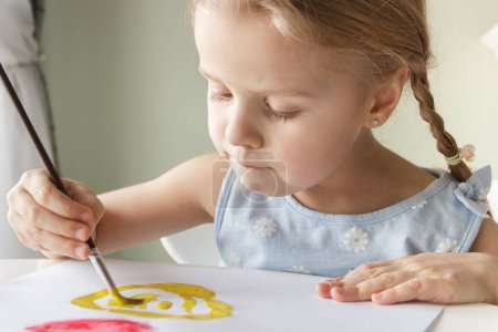 Foto de Pequeño niño dibuja con acuarela, concepto de educación en el jardín de infantes, fondo de enfoque suave - Imagen libre de derechos