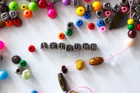 Photo for Word leisure made from colored beads on the thread, concept of designing or occupation of hand made, light background - Royalty Free Image