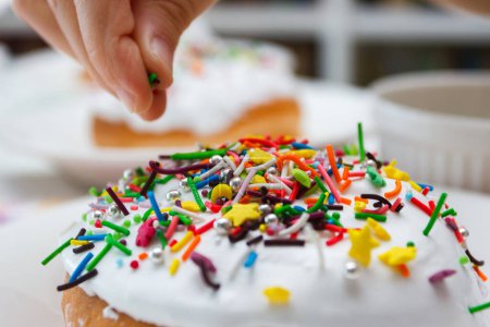 Foto de Proceso de decorar un pastel con decoraciones de colores dulces, concepto de cocción del pastel de Pascua - Imagen libre de derechos