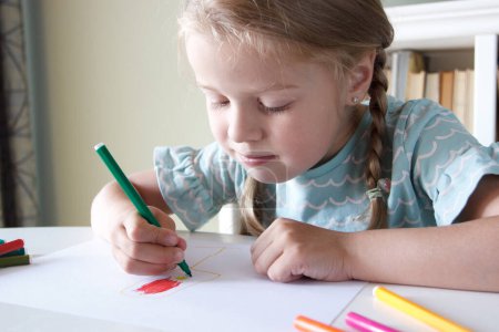 Téléchargez les photos : Enfant mignon dessinant une image avec des stylos feutre colorés. Concept de passe-temps et d'éducation - en image libre de droit