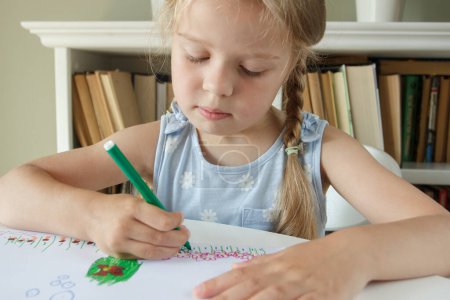 Téléchargez les photos : Enfant mignon dessinant une image avec des stylos feutre colorés. Concept de passe-temps et d'éducation - en image libre de droit