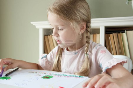 Photo for Cute child drawing a picture with colored felt-tip pens. Concept of hobby and education - Royalty Free Image