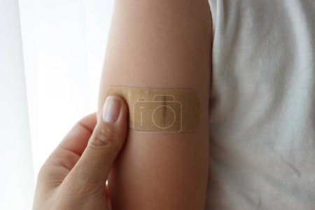 Photo for Arm with a plaster on the skin. Concept of vaccination and immunization, soft focus background - Royalty Free Image