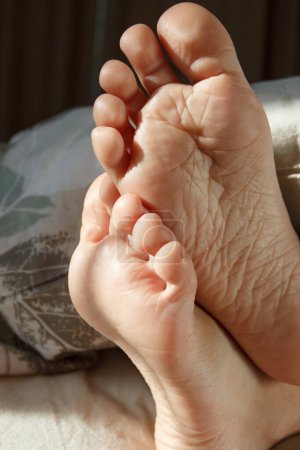 Photo for Feet under a light blanket on the bed. Concept of healthy life - Royalty Free Image