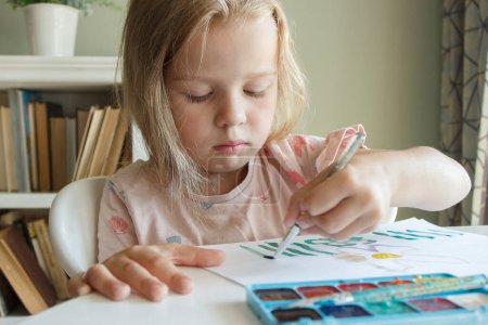Téléchargez les photos : Petit enfant dessine à l'aquarelle, concept d'éducation à la maternelle, arrière-plan soft focus - en image libre de droit