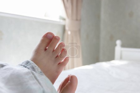 Photo for Feet under a light blanket on the bed. Concept of health and life style - Royalty Free Image