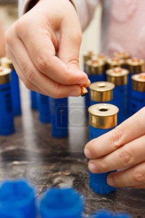 Téléchargez les photos : Un homme faire la réparation du boîtier en plastique pour la fabrication d'une cartouche pour le tir ou la chasse - en image libre de droit