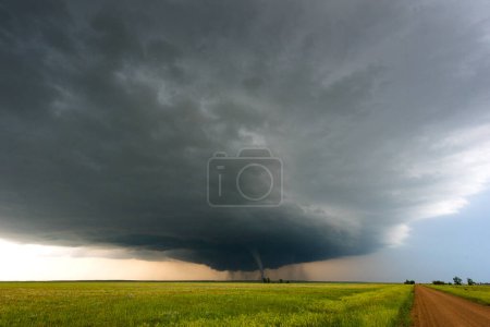 Distant Tornado Under Dark Storm Clouds Along A Dusty Road