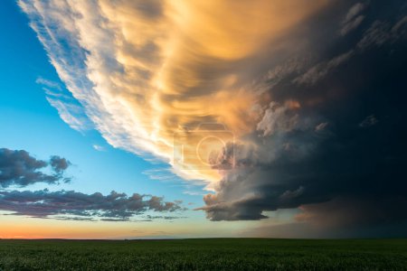 Téléchargez les photos : De belles couleurs remplissent le ciel au coucher du soleil avec des nuages de tempête qui s'estompent - en image libre de droit