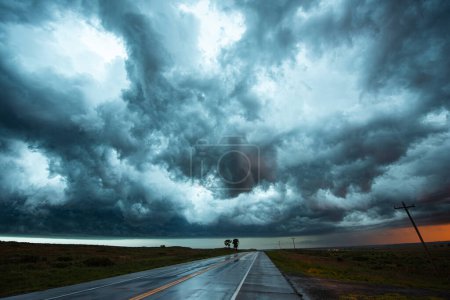 Téléchargez les photos : De belles textures et couleurs de nuages remplissent le ciel au-dessus d'une route vide - en image libre de droit