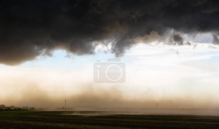 Téléchargez les photos : Poussière soufflant sous les nuages sombres de tempête - en image libre de droit