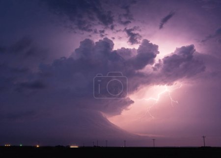 Téléchargez les photos : La foudre éclaire les nuages sombres de la tempête dans le ciel nocturne - en image libre de droit