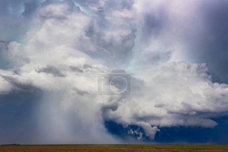 Powerful storm cloud downburst with lightning crossing the sky