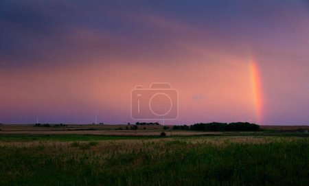 Téléchargez les photos : Couleurs pastel et arc-en-ciel remplissent le ciel comme le soleil se couche - en image libre de droit