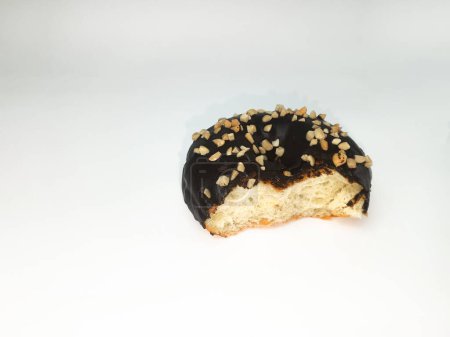 Ein gebissener Schokoladen-Donut mit Erdnussstücken isoliert auf weißem Hintergrund. Frühstücksgebäck Donut. Raum für Text. Kopierraum.