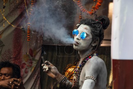 Téléchargez les photos : Naga sadhu fumer à ganga sagar transit camp kolkata - en image libre de droit