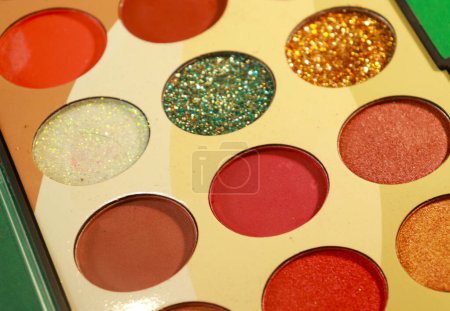 Multicolor eyeshadow make-up palette in green screen background, close-up. Professional cosmetic product. Eye shadows palette as beauty product cosmetic powder for makeup eye, brown color scheme, matte and shimmer tints.