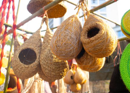 straw nest kept for bird hatching. Handcrafted bird nest on shop for sale.A pile of handmade traditional woven baskets made from straw, natural fiber, for sale at the outdoor market.