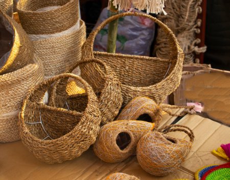 Nido de aves hecho a mano en la tienda en venta. Paja tradicional, bambú. Expositor de artesanías hecho con caña. Una pila de cestas tejidas tradicionales hechas a mano hechas de paja, fibra natural, para la venta en el mercado.