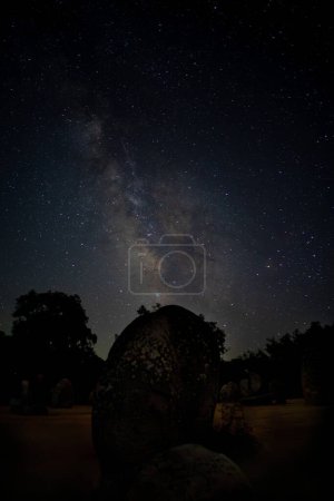 Stunning Milky Way galaxy above the ancient Almendres Cromlech, creating a mesmerizing celestial backdrop.