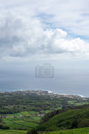 Luftaufnahme von Porto Martins auf der Insel Terceira, Azoren, mit dem riesigen Atlantik als Hintergrund. Atemberaubende Küstenlandschaft von oben eingefangen.
