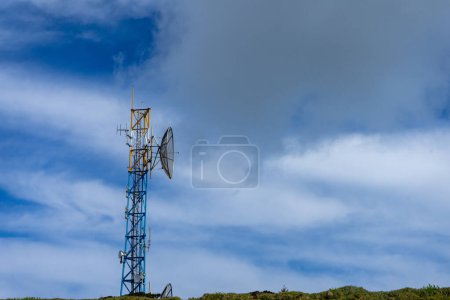 Foto de Moderna torre de telecomunicaciones se alza sobre el dramático telón de fondo de la montaña en Serra do Cume, Isla Terceira, Azores. Un símbolo de conectividad en la belleza remota. - Imagen libre de derechos