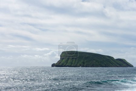 Foto de Vistas panorámicas de Ilhu das Cabras, un pequeño islote frente a la isla Terceira, Azores, con escarpados acantilados y exuberante vegetación. - Imagen libre de derechos