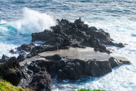 Mächtige Wellen krachen entlang der Küste von Cinco Ribeiras, einem malerischen Badegebiet auf der Insel Terceira, Azoren.