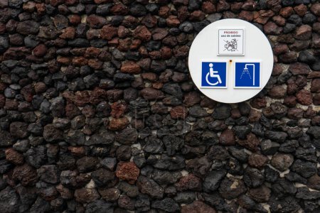 Signage indicating a shower area with facilities for both regular and disabled individuals, situated in a beachfront location.