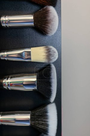 A neatly organized display of makeup brush caps, lined up in rows on a store shelf. The caps vary in size and design, reflecting a diverse range of makeup tools