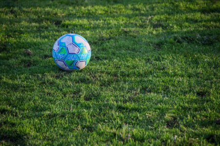Soccer ball resting on lush green turf, epitomizing the essence of the beautiful game. Perfect for sports-themed designs.