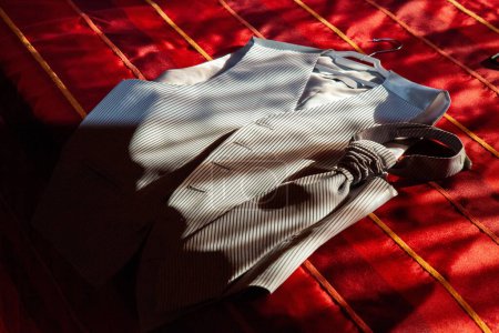 Photo for Groom's suit vest and tie laid on bed, pre-wedding. Elegant ensemble for groom's attire. - Royalty Free Image