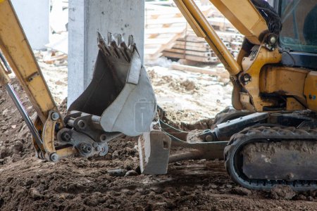 Photo for Close-up view of an excavator claw scoop digging into earth, capturing the power and precision of heavy machinery in action. - Royalty Free Image