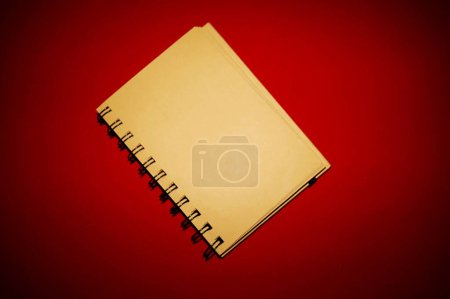 notepad with leaves, pages produced naturally with recycled materials, on a red background