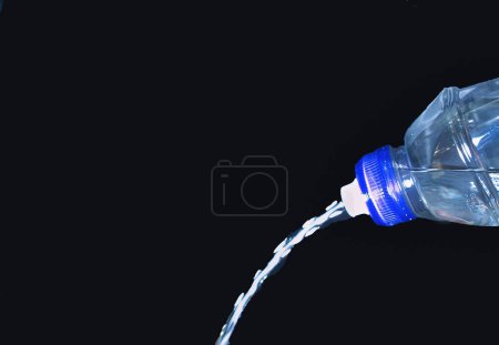 Water Pouring Out of Plastic Bottle on a black background