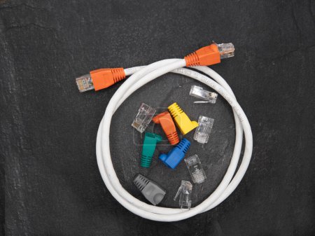 Bottes de protection réseau local ou LAN, connecteurs RJ45 et câble réseau complet isolés sur fond sombre