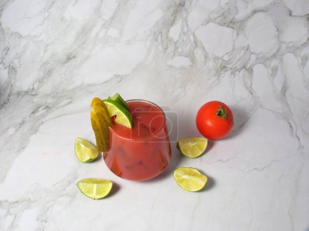 Würziger blutiger oder jungfräulicher Marien-Cocktail im Glas mit Selleriestangen, Gurken, Limetten und Tomaten.