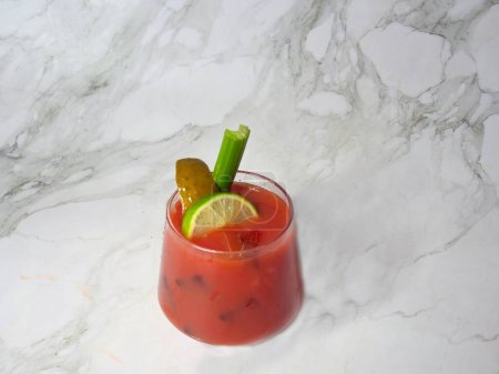 Würziger blutiger oder jungfräulicher Marien-Cocktail im Glas mit Selleriestangen, Gurken, Limetten und Tomaten.