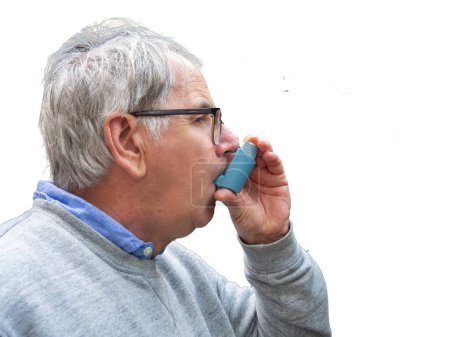 Senior man using asthma pump