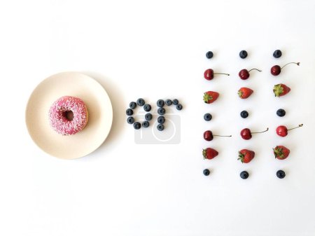 Rosado donut y bayas. Fresas, arándanos y cerezas. Conciencia. Elección de comida. Estilo de vida saludable.
