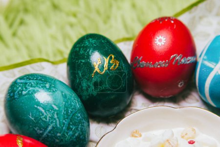 Genießen Sie die frohen Traditionen des orthodoxen Osterfestes durch leuchtende Schriftzüge wie "Christus ist auferstanden" und "Frohe Ostern", leuchtend marmorierte Eier und einen weichen grünen Hintergrund..