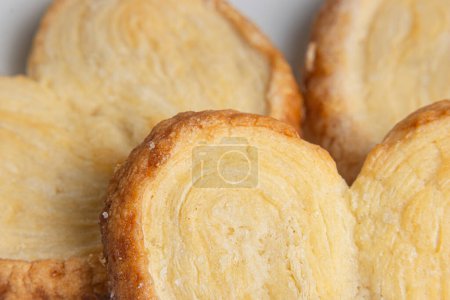 Detail and close-up of a puff pastry cookie on other cookies in the background