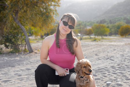 Photo for Beautiful young girl and her cocker spaniel dog having fun on the beach on a hot spring day, mountains in the background, sunset. High quality photo - Royalty Free Image