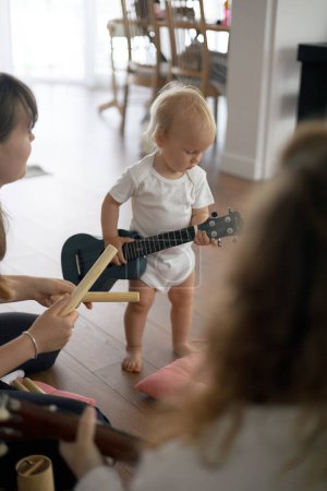 Photo for Little toddler girl playing ukulele in music class. - Royalty Free Image