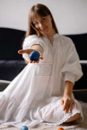 Ein Ball mit Füllstoff zur Entwicklung der Feinmotorik von Kinderhänden in den Händen einer Lehrerin, verschwommener Hintergrund