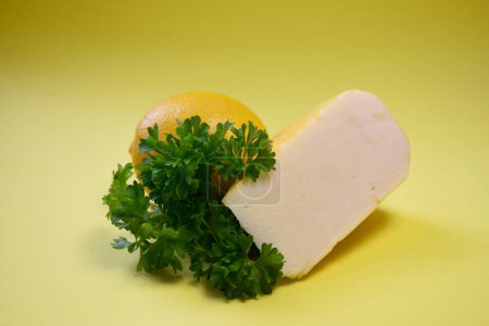 cheese, lemon, herbs on a yellow background in the shape of a heart