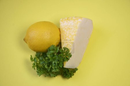 cheese, lemon, greens on a yellow background